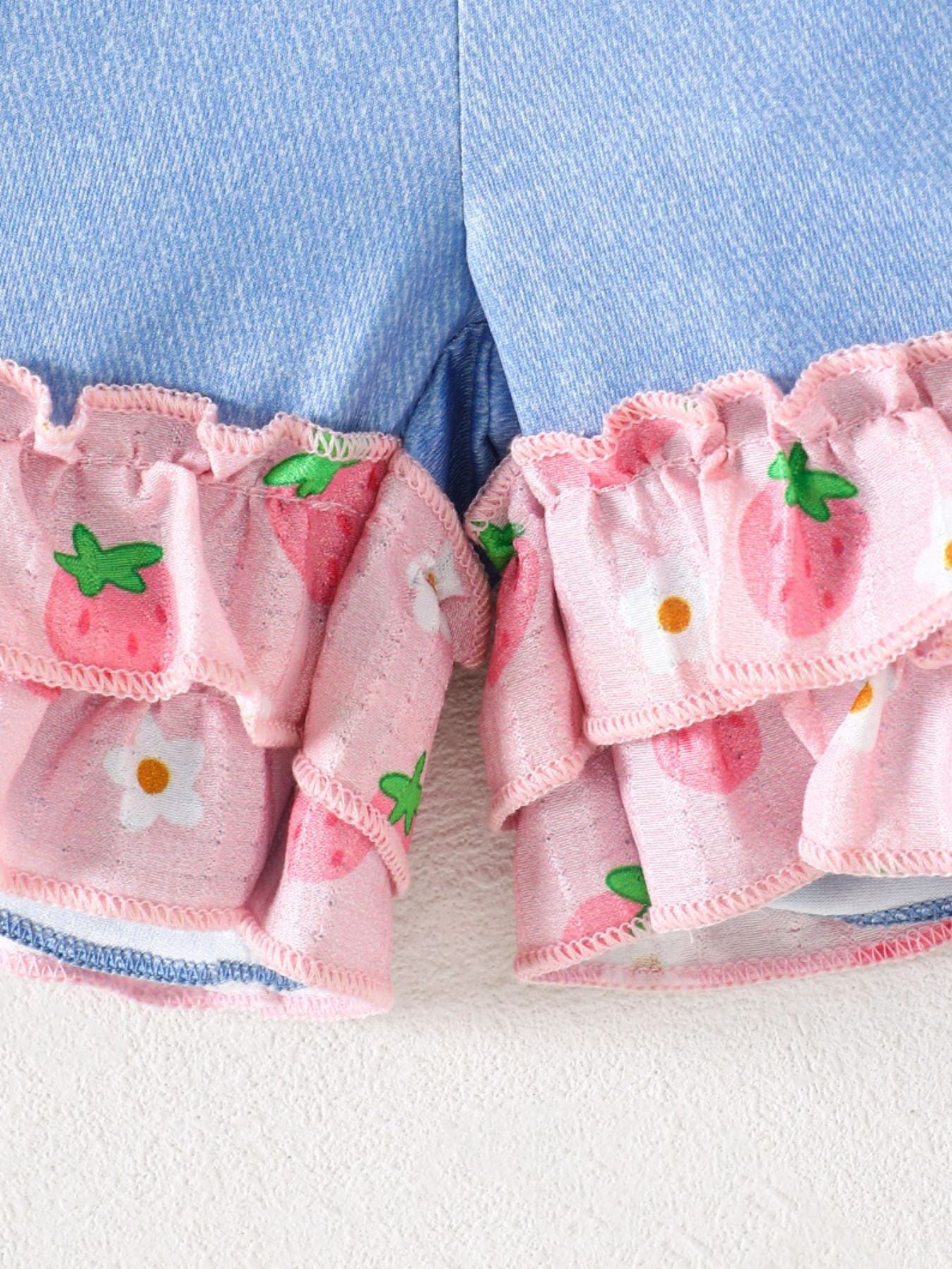 Baby cami set with strawberry print ruffles and denim shorts.