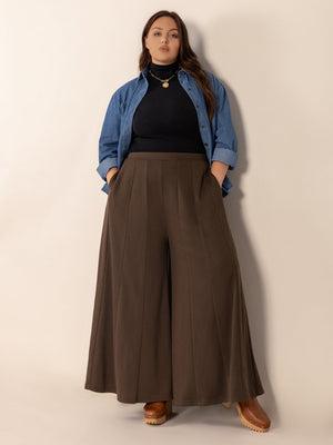 Sculpted flare palazzo trousers in dark brown with vertical seam details and pockets.