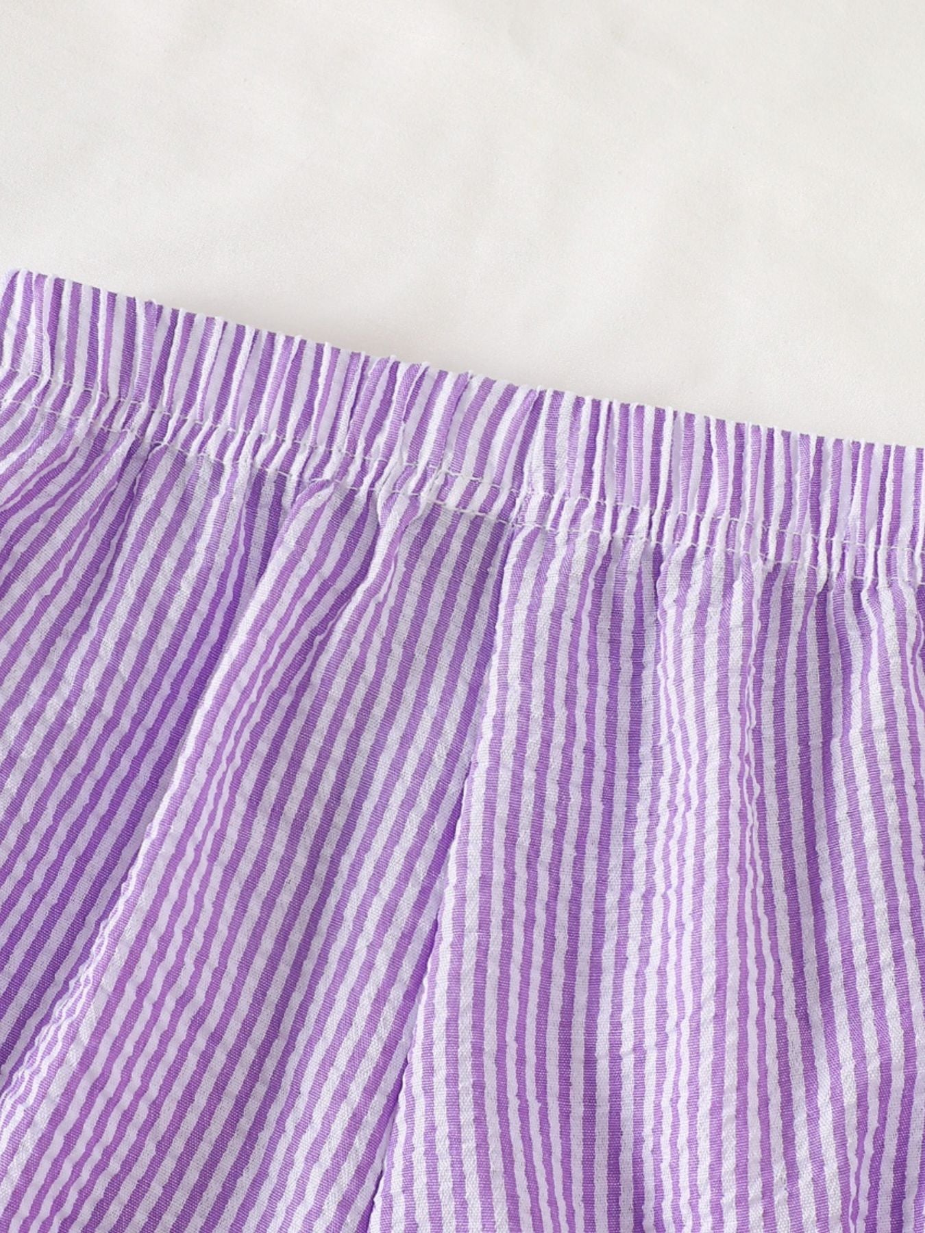 Children's purple and white striped seersucker shorts with elastic waistband.