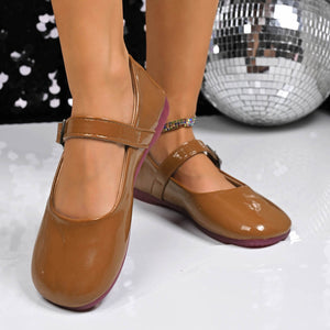 Brown patent buckle strap Mary Jane loafers with a purple sole.