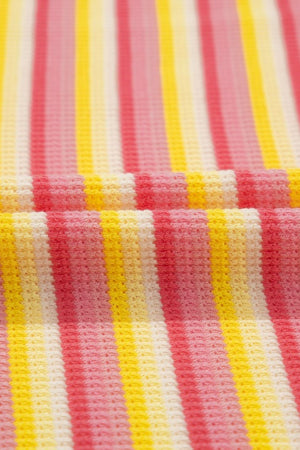 Rainbow stripe culotte jumpsuit in sherbet, pink, and yellow cotton knit with a waffle texture.