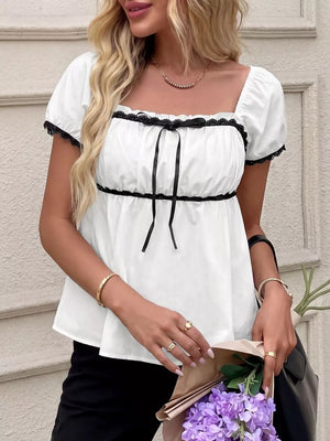 White maternity blouse with black lace trim and bowknot detail