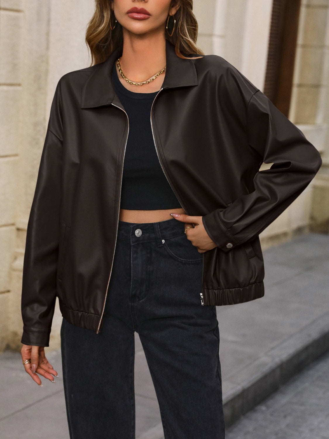 Brown faux leather bomber jacket with zip front and elastic cuffs.