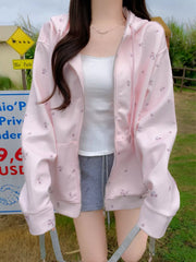 Pink floral zip-up hoodie with drawstring and white tank top.