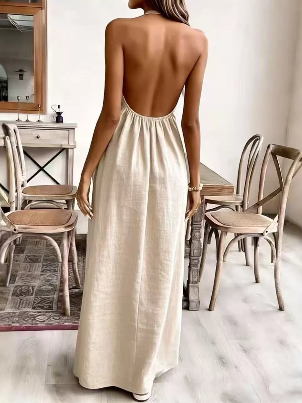 Cream white ruched halter maxi gown with a low open back and flowing skirt.