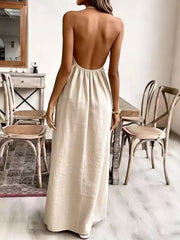 Cream white ruched halter maxi gown with a low open back and flowing skirt.