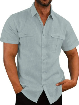 Men's light blue textured linen utility shirt with short sleeves and two chest pockets.