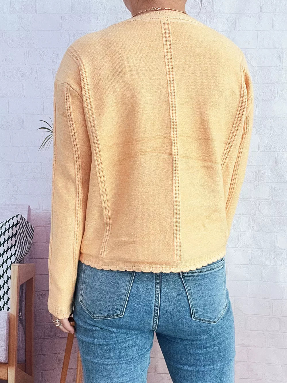 Yellow button up cardigan with scalloped hem and textured seams.