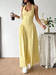 Yellow V-neck ruched maxi dress with empire waist and halter straps.