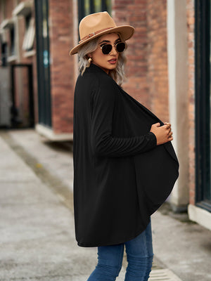 Black asymmetrical drape front cardigan with long sleeves, styled with a hat and sunglasses.