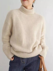 Cozy apricot acrylic turtleneck sweater with dropped shoulders and ribbed cuffs.