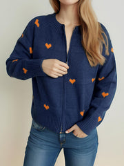 Dark blue zip-through knit cardigan with allover orange heart appliqué, crew neck, and ribbed cuffs.