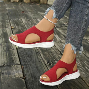 Red knit open-toe platform sandals with white soles and elastic ankle straps.
