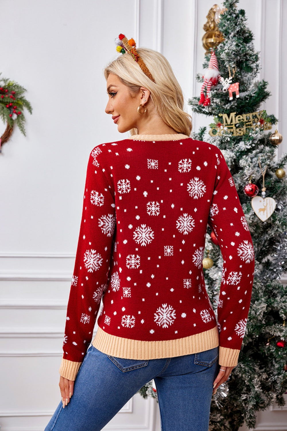 Red acrylic knit sweater with white snowflake pattern and tan trim.