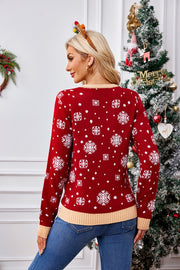 Red acrylic knit sweater with white snowflake pattern and tan trim.