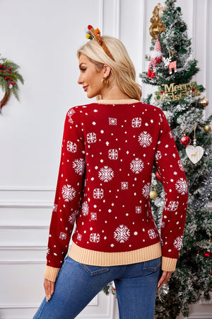 Red acrylic knit sweater with white snowflake pattern and tan trim.