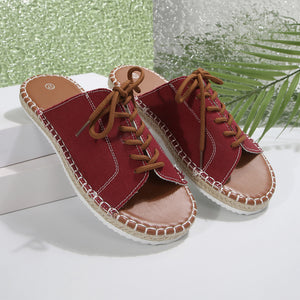 Red canvas lace-up open-toe flats with espadrille trim and brown laces.
