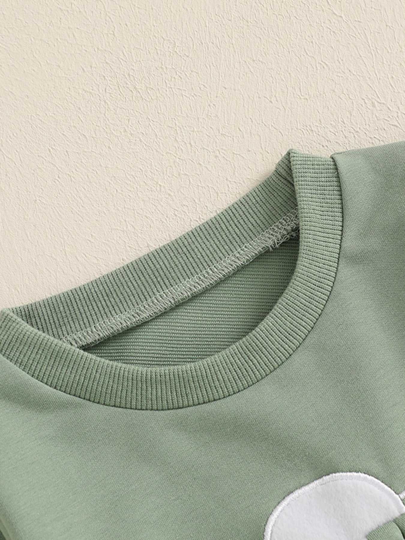 Green cotton baby outfit with bunny applique detail and ribbed crew neck.
