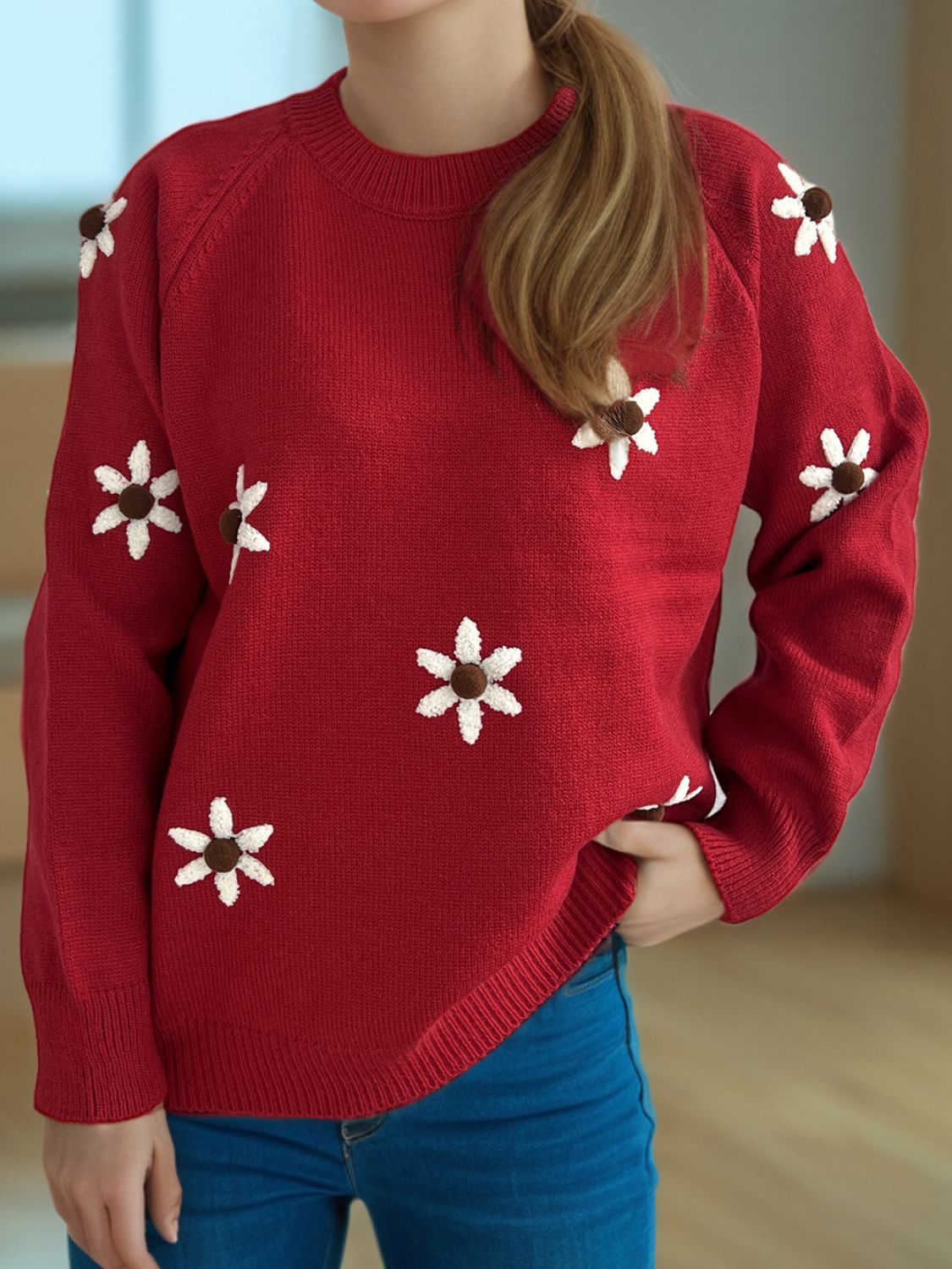 Burgundy knit sweater with embroidered white flowers and brown centers, crew neck, raglan sleeves.