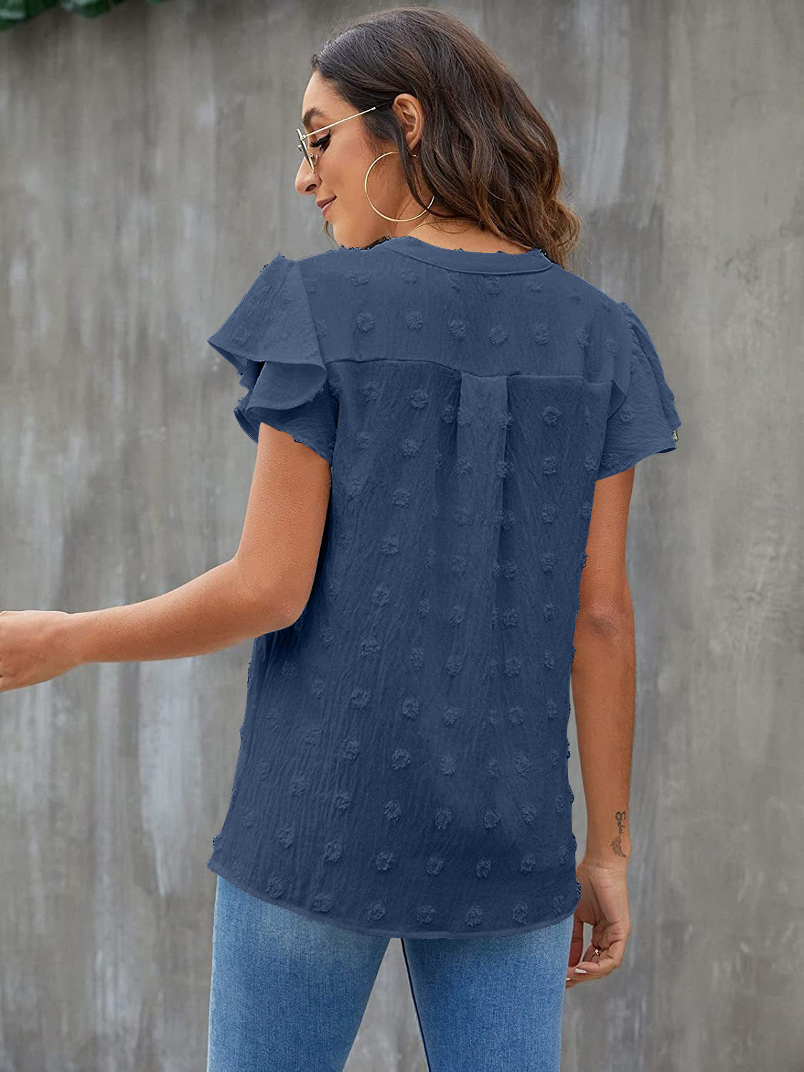 Textured voile blouse in dark blue with flutter sleeves and dotted pattern.