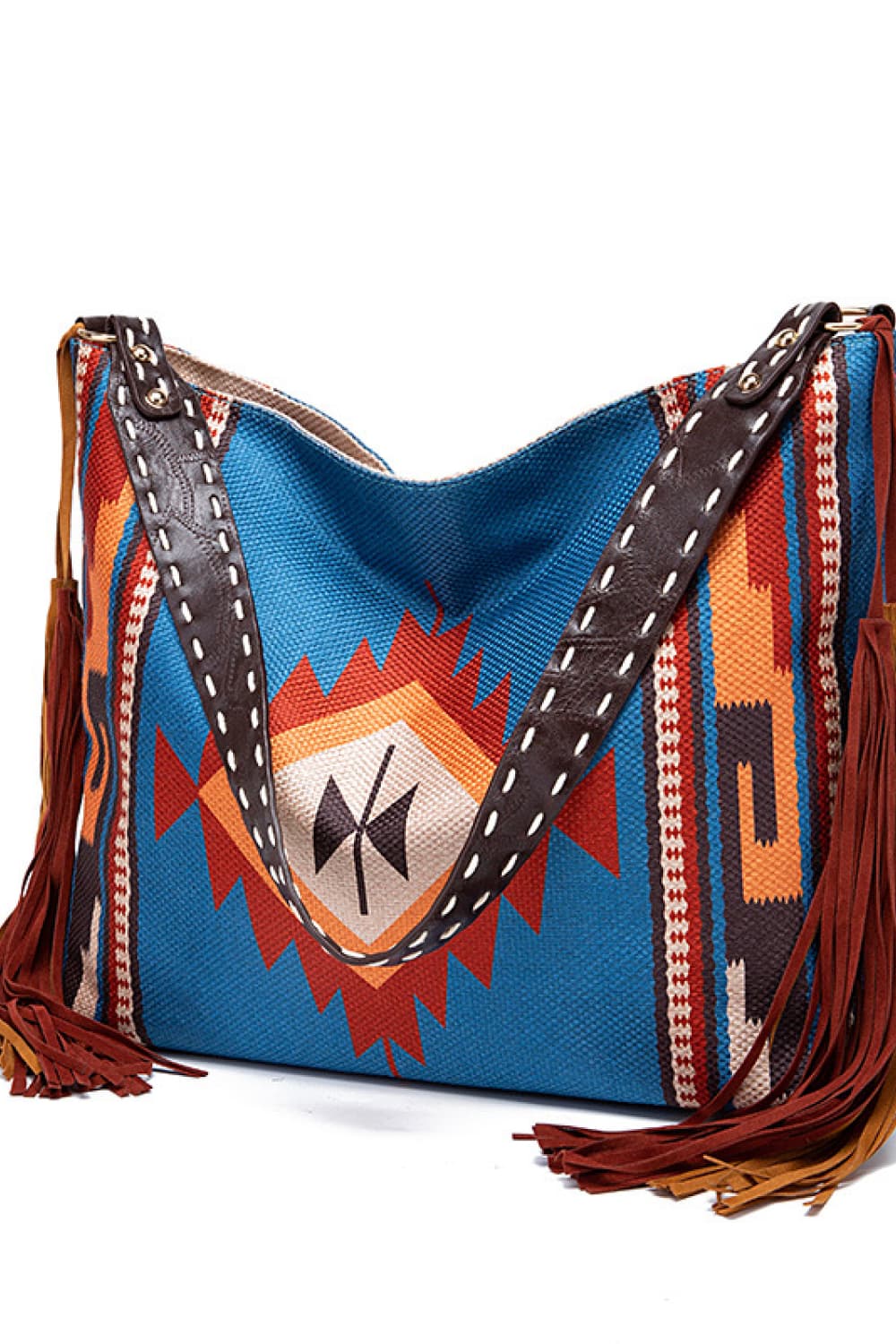 Southwestern fringe hobo bag in blue with geometric pattern and brown leather strap.
