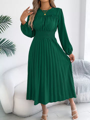 Green midi dress with ruffled neckline, smocked waist, and pleated skirt.
