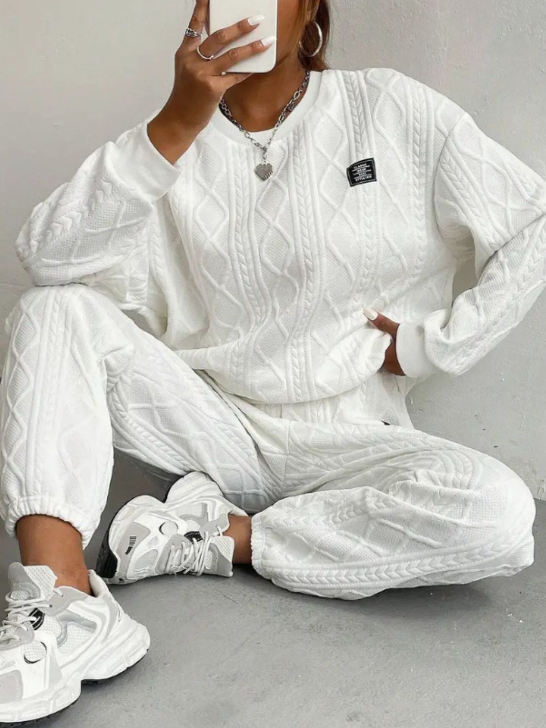 White cable knit loungewear set with crewneck sweatshirt and jogger pants.