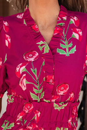 Charming floral midi dress in magenta with ruffled V-neck and cinched waist.