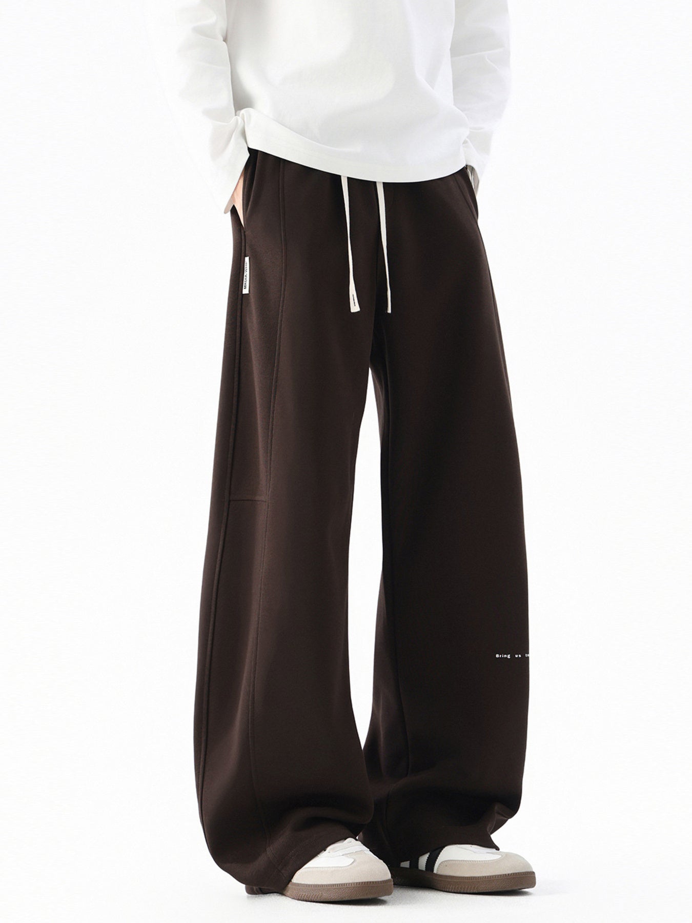 Men's dark coffee casual drawstring pants with wide leg and subtle logo detail.