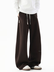 Men's dark coffee casual drawstring pants with wide leg and subtle logo detail.