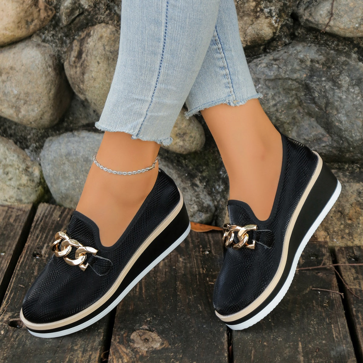 Black wedge loafers with gold chain detail and textured upper
