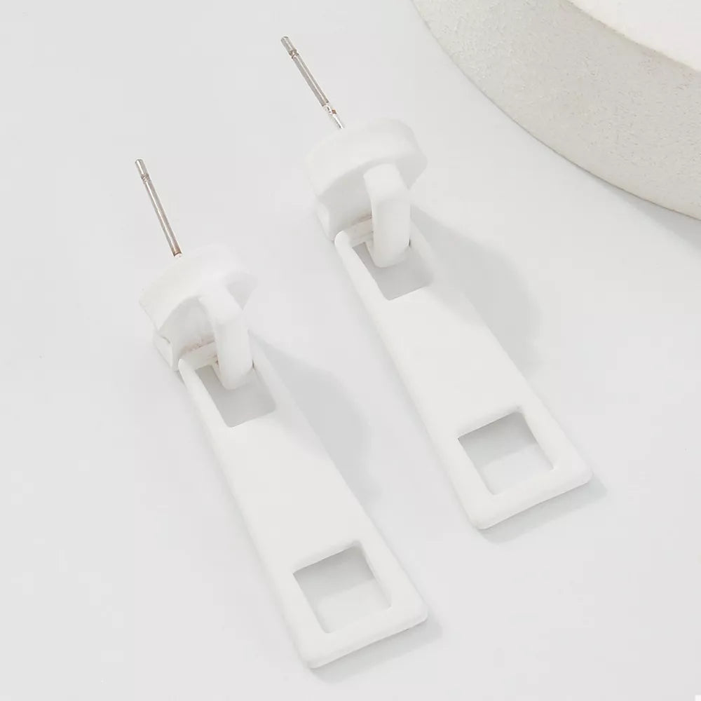 White zipper drop earrings with square cutouts and alloy posts.