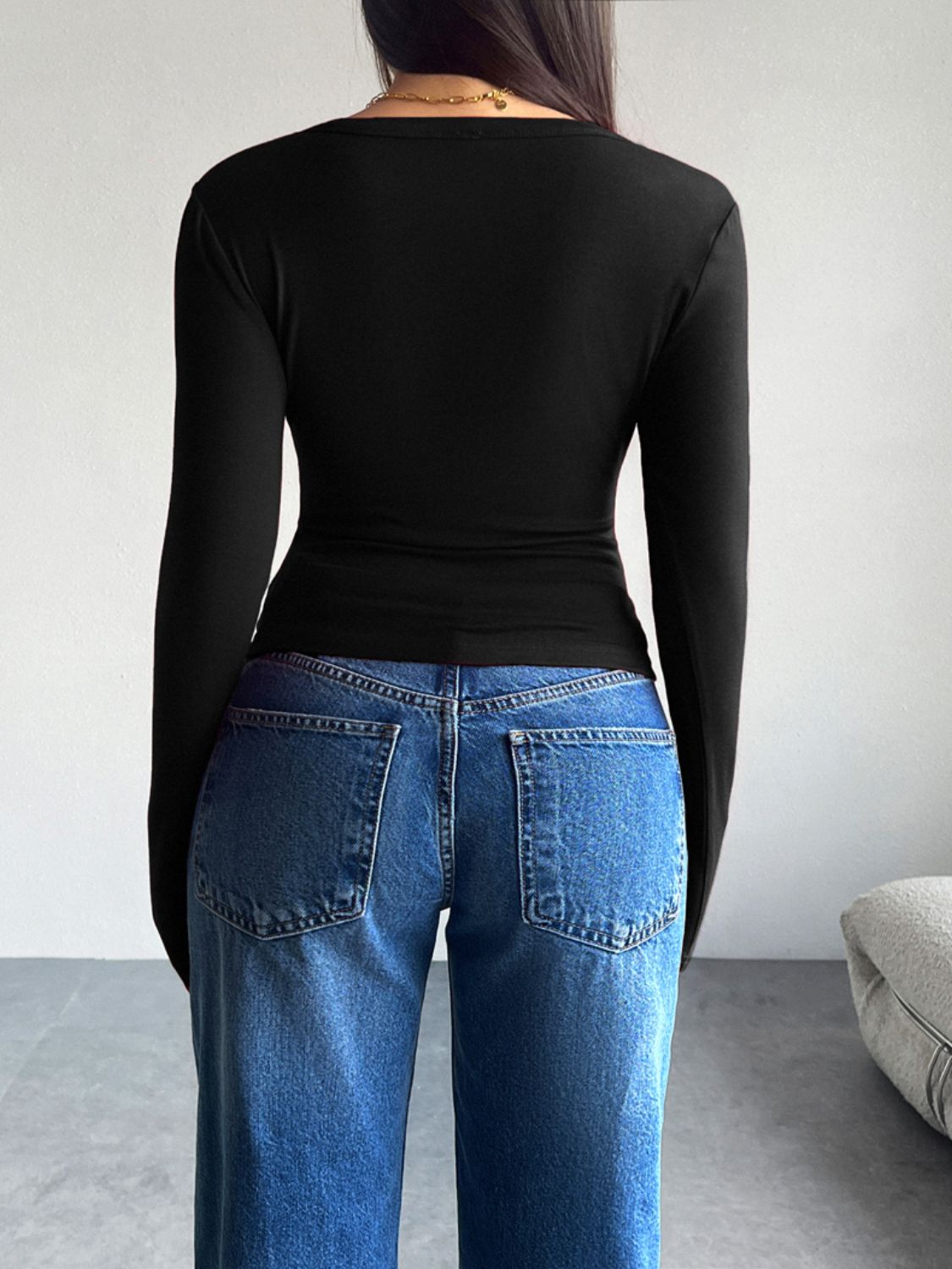 Black button-up cardigan with long sleeves, shown from the back.