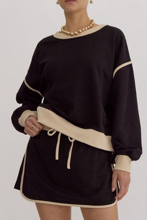 Black sweatshirt and skort set with contrast trim and drawstring waist.
