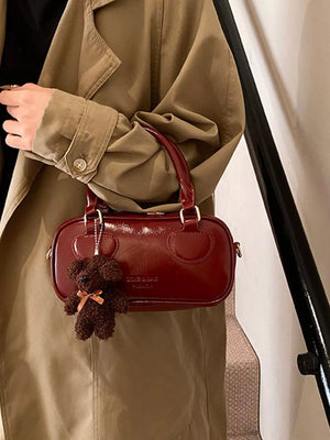 Chic mini crossbody bag in deep red PU leather with a teddy bear charm.
