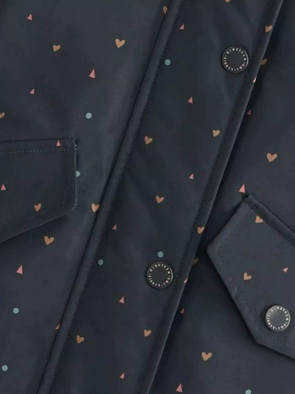 Toddler navy jacket with all-over heart and triangle print, featuring button details and pocket flaps.