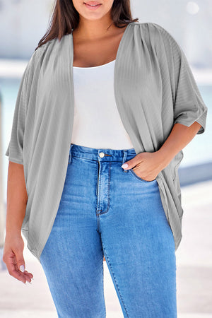 Light gray ribbed batwing cardigan with draped front, styled with a white tank and jeans.