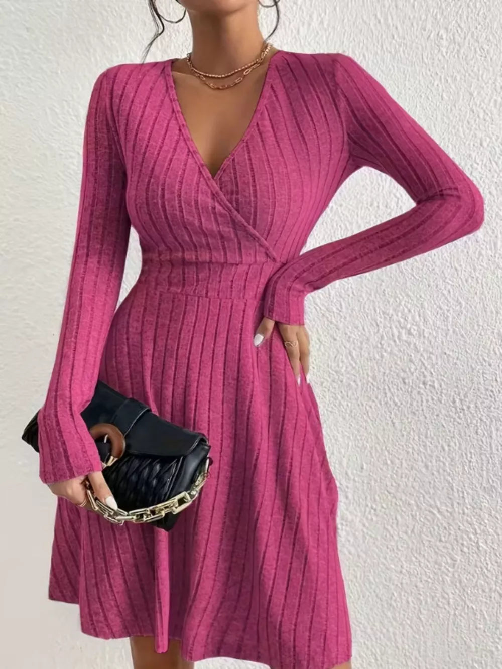 Fuchsia pink ribbed wrap mini dress with V-neck and long sleeves.