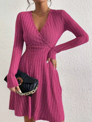 Fuchsia pink ribbed wrap mini dress with V-neck and long sleeves.