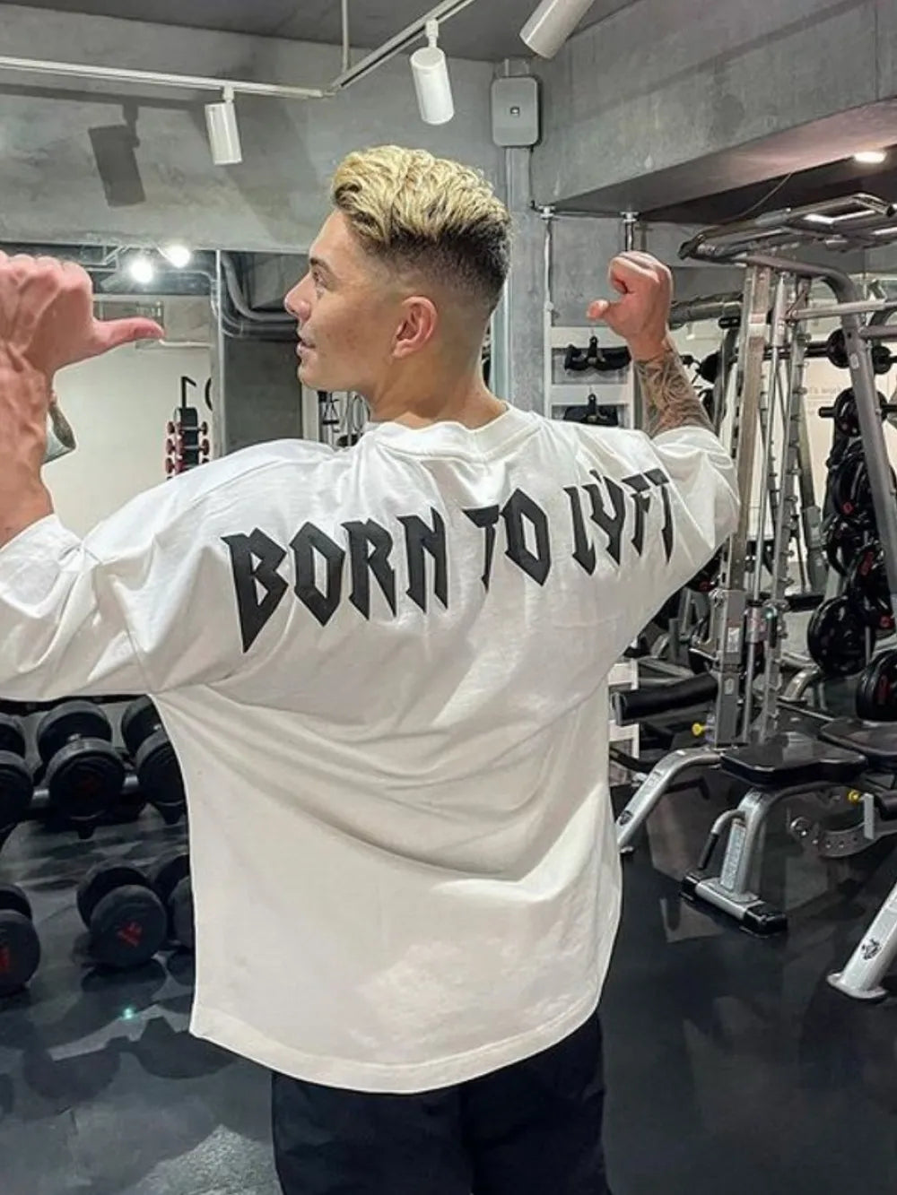 White oversized graphic tee with black "BORN TO LYFT" text on back