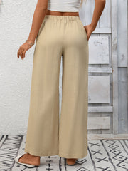 Apricot high-waist wide-leg pants with drawstring and pockets.