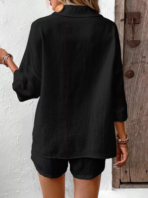 Black cotton two-piece set with button detail on collar and cuffed sleeves.
