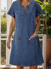 Denim trapeze dress in dusty blue with V-neck and patch pockets.