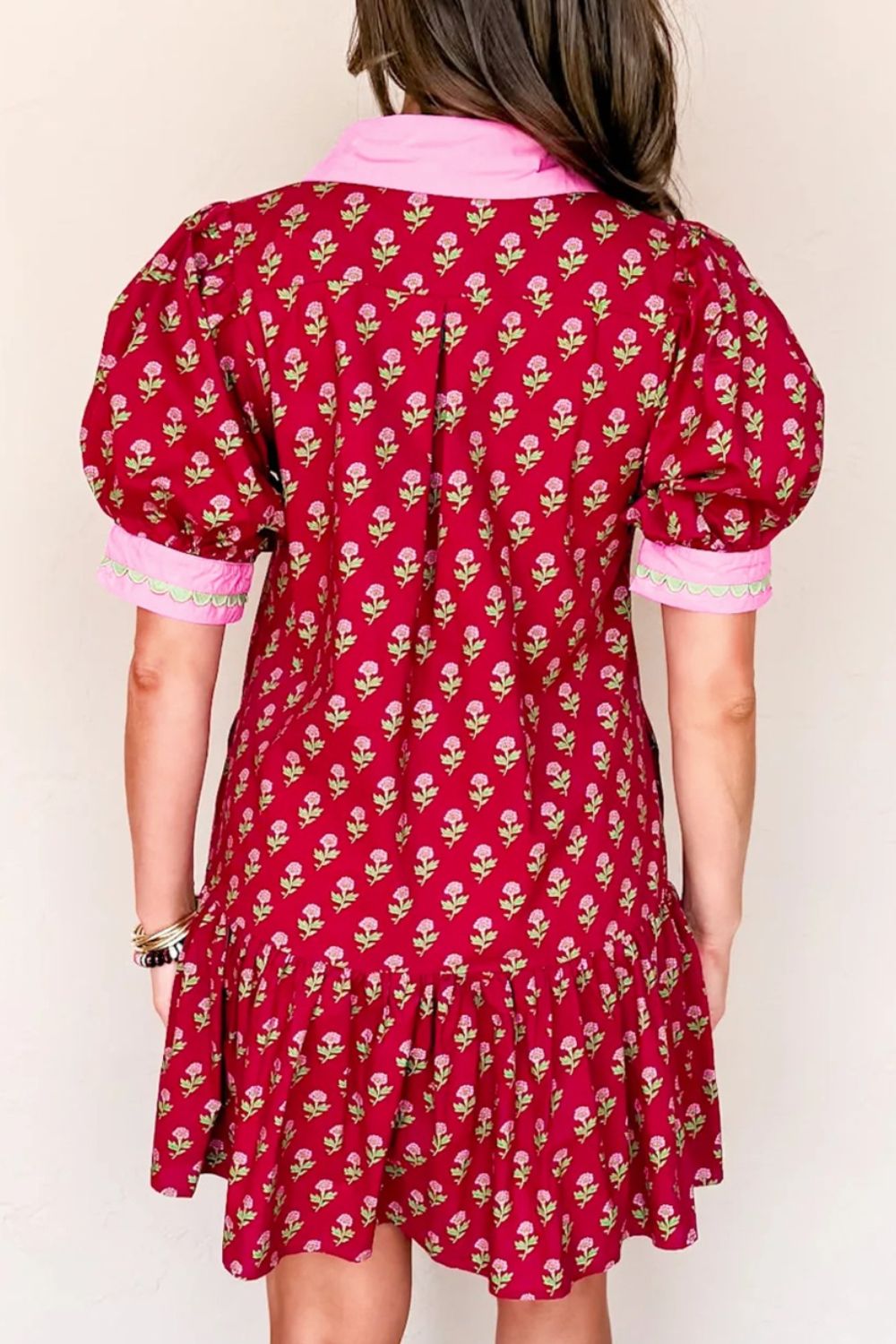 Red floral mini dress with puff sleeves, ruffled hem, and pink collar.