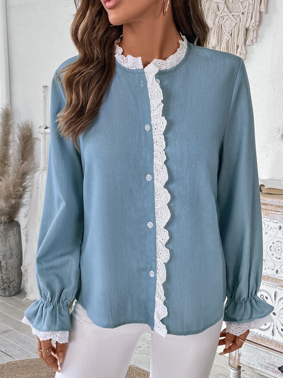 Light blue button-up blouse with white lace trim on the neckline and cuffs.
