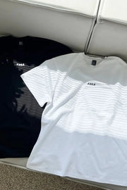 Oversized white and black t-shirts with drop shoulders and small chest logos.
