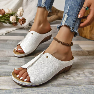 White glossy crocodile-embossed wedge slide sandals with open toe.