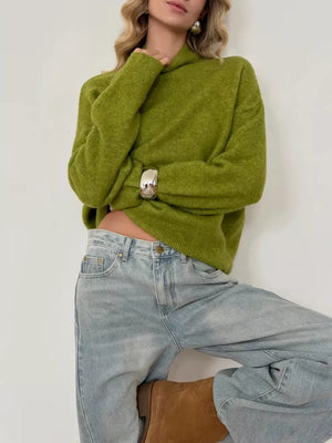 Moss relaxed mock neck knit sweater with a textured acrylic blend, styled with light wash jeans.