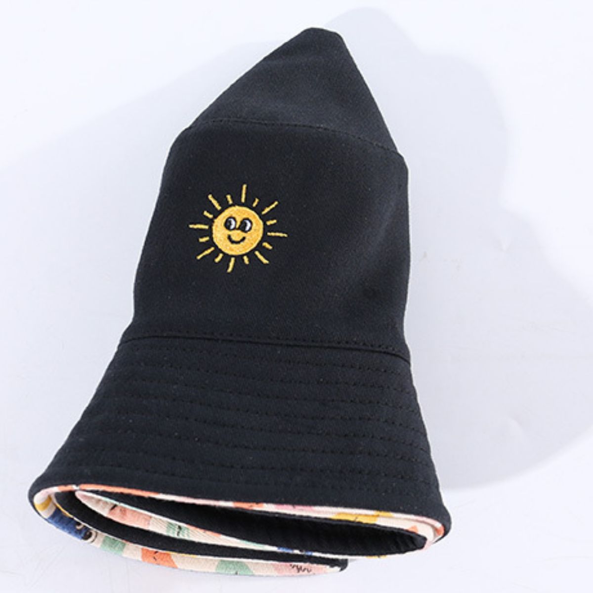 Black cotton bucket hat with embroidered yellow sun detail and abstract print lining