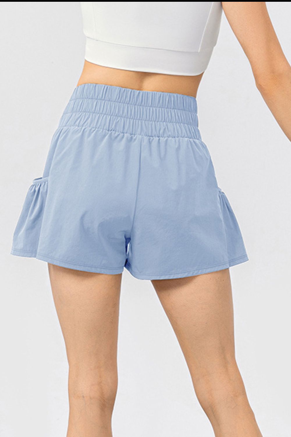 Light blue active shorts with gathered waistline and ruffled side pockets.
